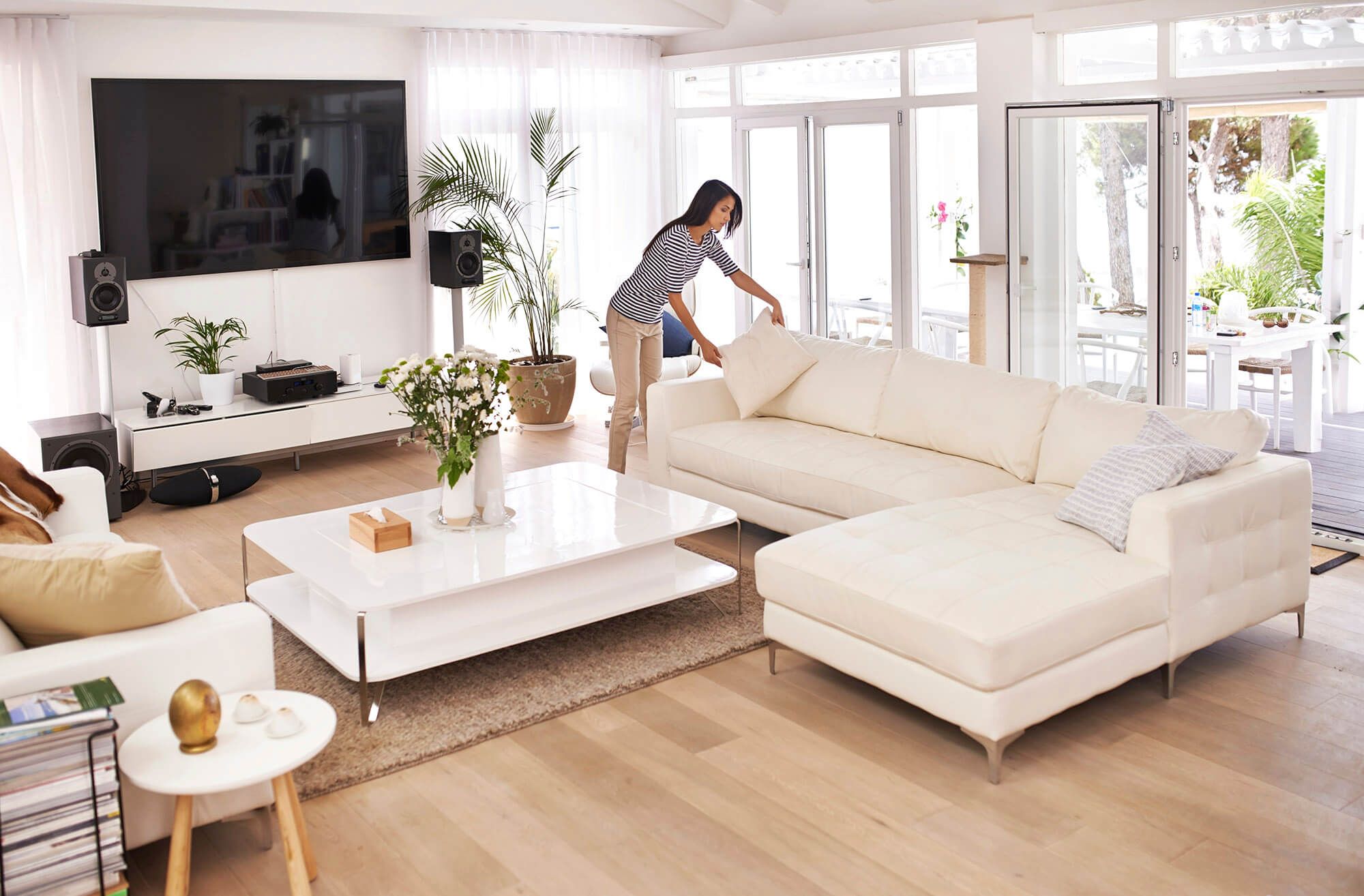 Woman Placing Pillows On A White Couch
