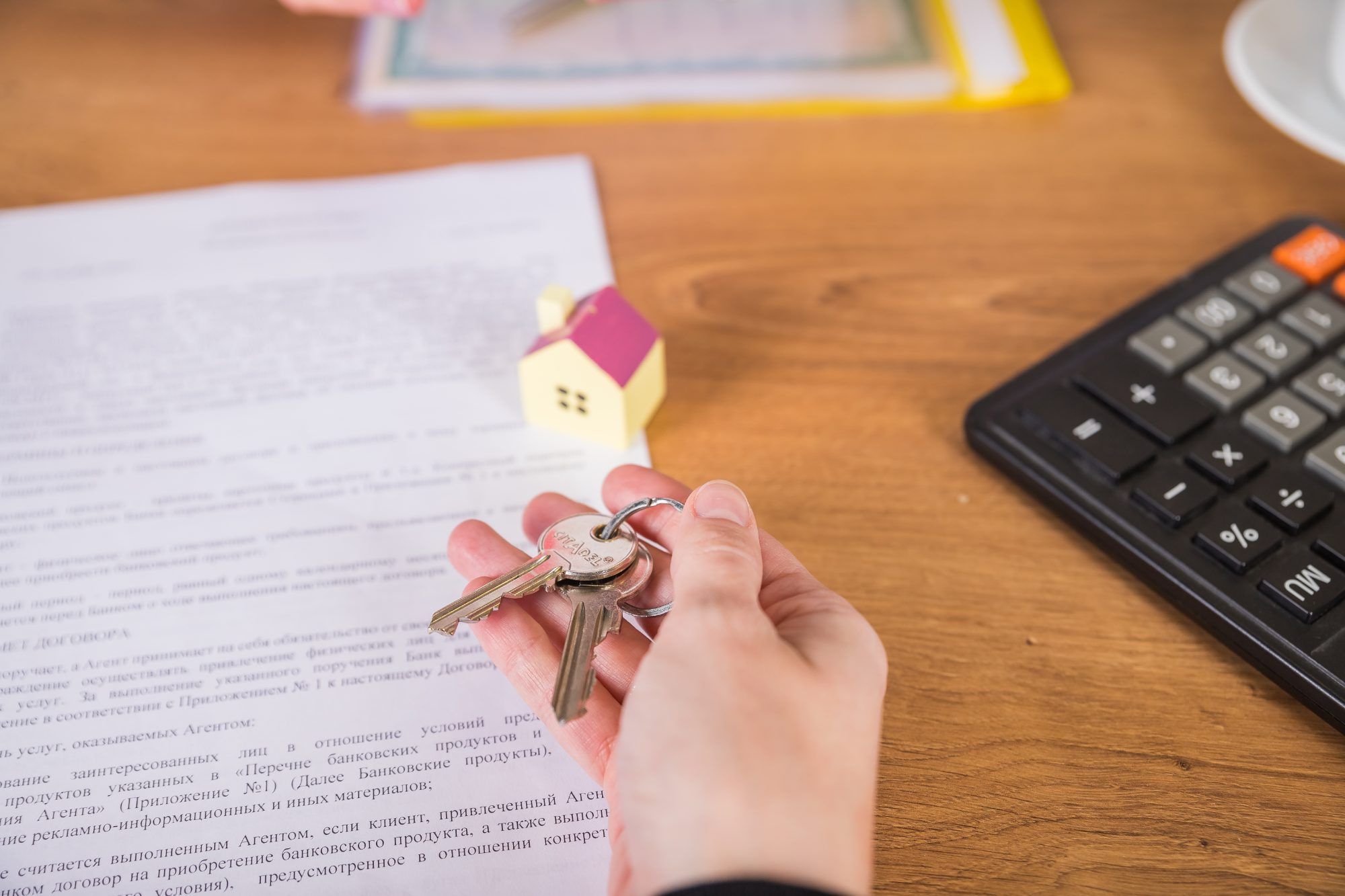 Home purchase contract with house keys and a calculator