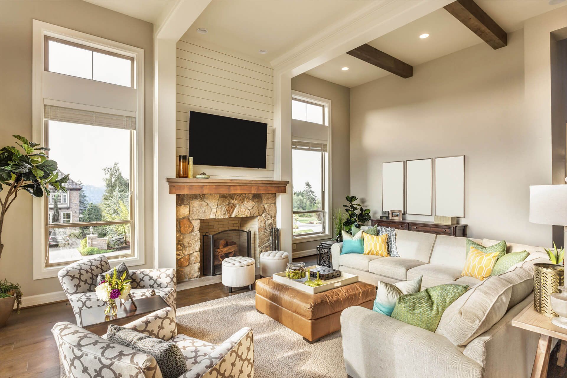 Bright living room with vaulted beamed ceiling and stone fireplace