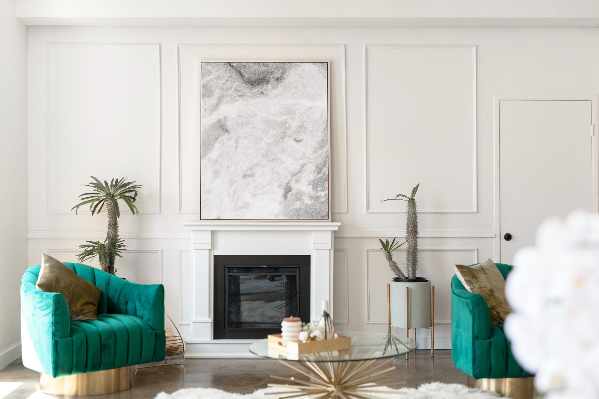 Living room with a fireplace and green armchairs, staged for sale