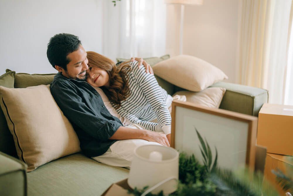 Couple cuddles on couch