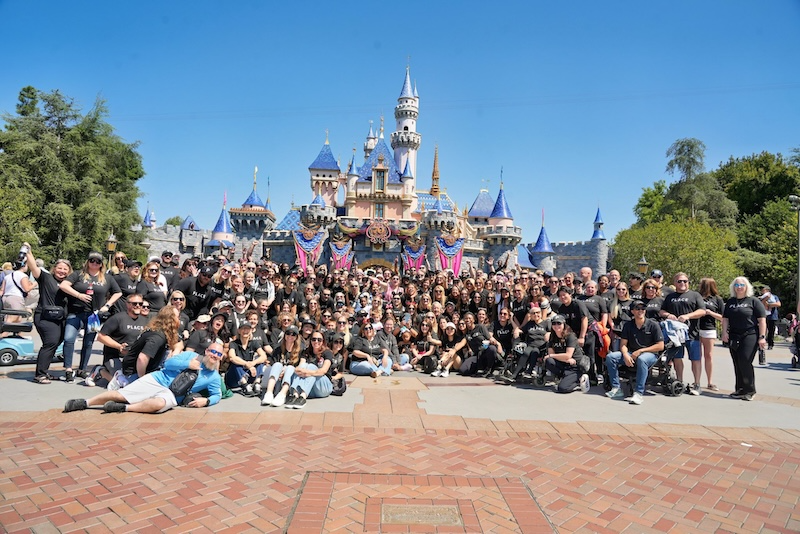 1,100 PLACE agents in matching black PLACE t-shirts at Disneyland in front of Sleeping Beauty Castle, the day after PLACE Winners 2026 in Anaheim