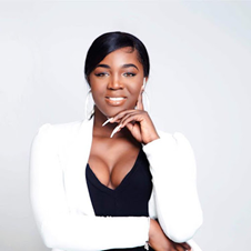 Confident African American woman in professional attire with a blazer and white top smiling outdoors