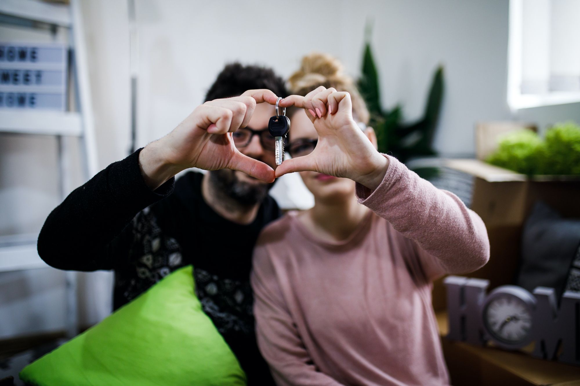 couple makes heart shape with hands with house keys