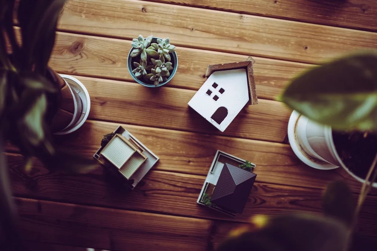 Model houses on a wooden table, representing a real estate portfolio