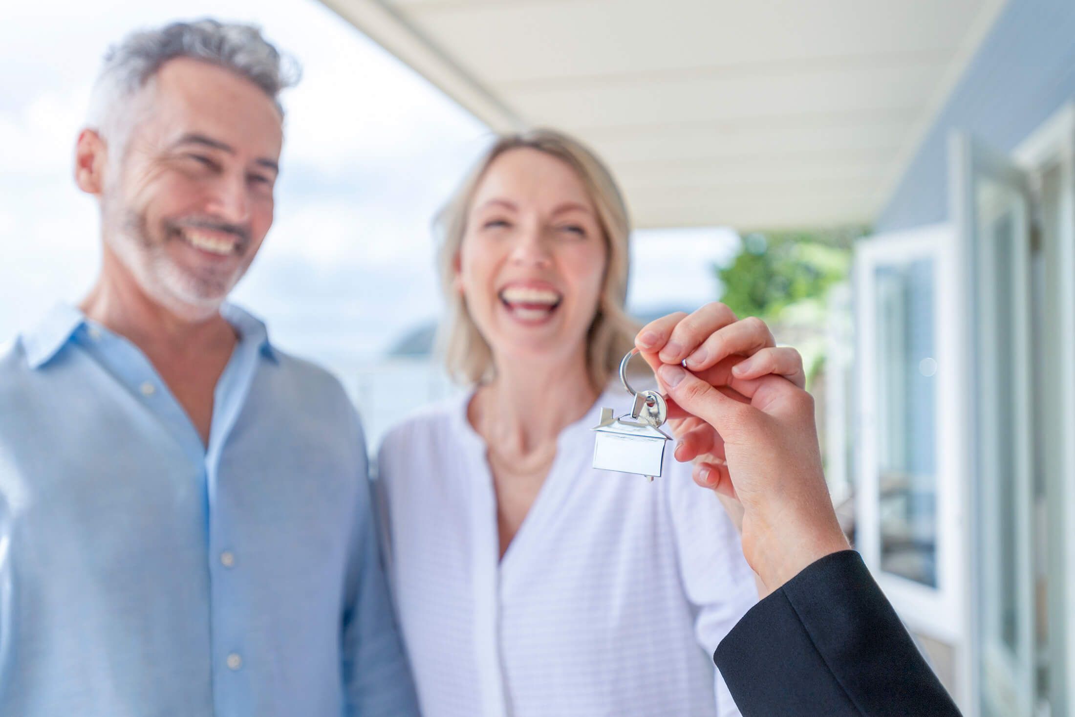 happy couples getting a key to their new property