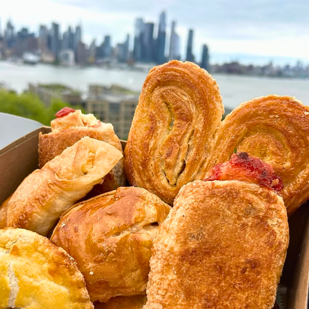 Plate with hamburger, French fries, lettuce, tomato, and onion sandwich with side of French fries on a white table, accompanied by a glass of dark soda, ketchup, and salt and pepper shakers.