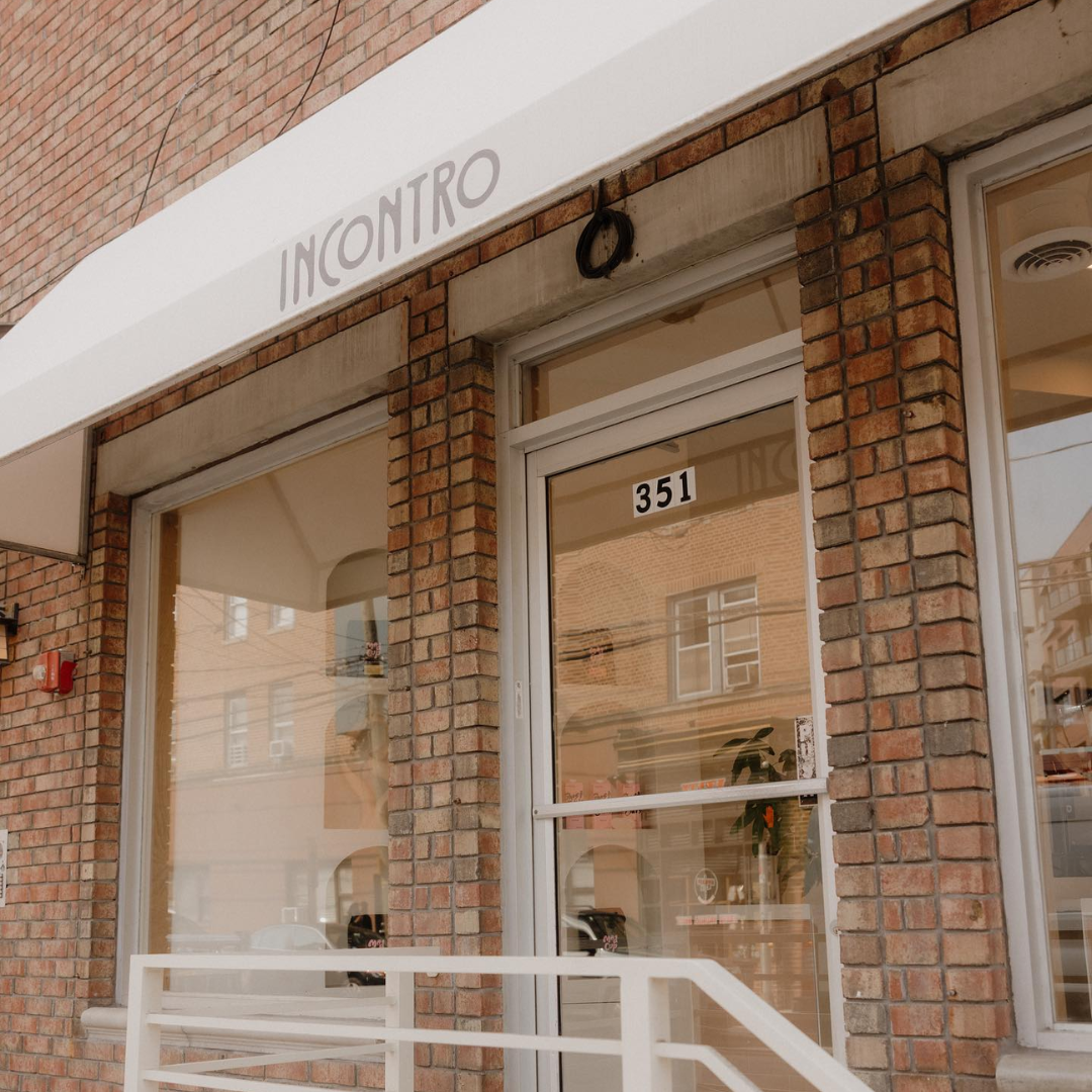 Exterior view of a brick building with a white awning labeled 