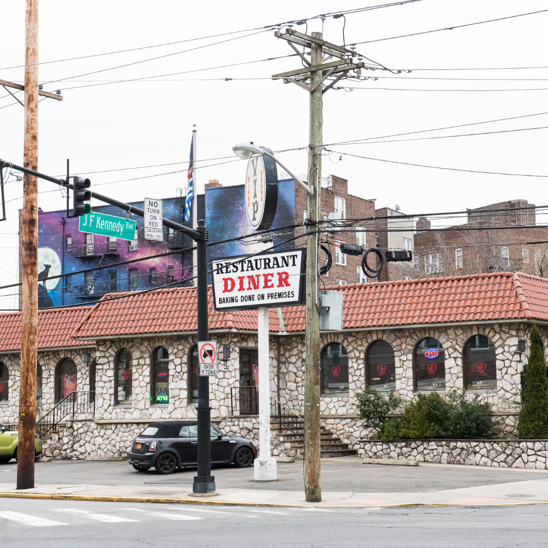 Stone building with a red tile roof, neon 
