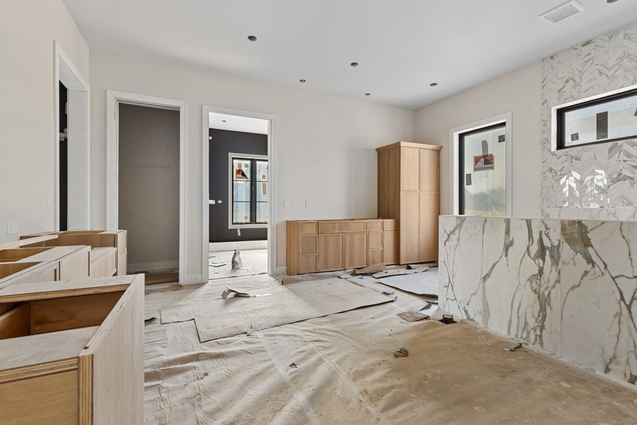Primary suite bath and closet under construction with marble accent wall