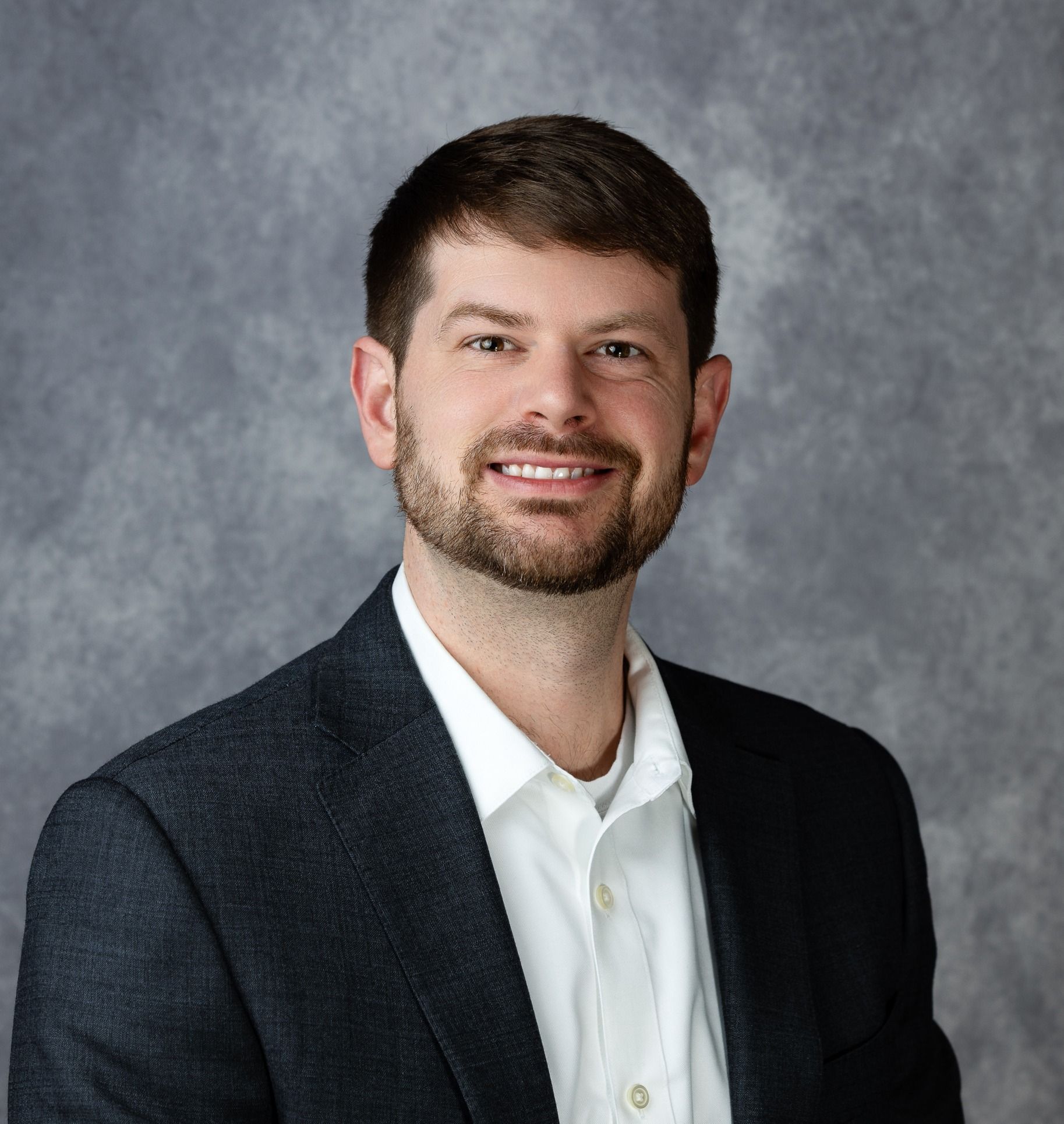 Professional businessman smiling outdoors with cityscape and river background