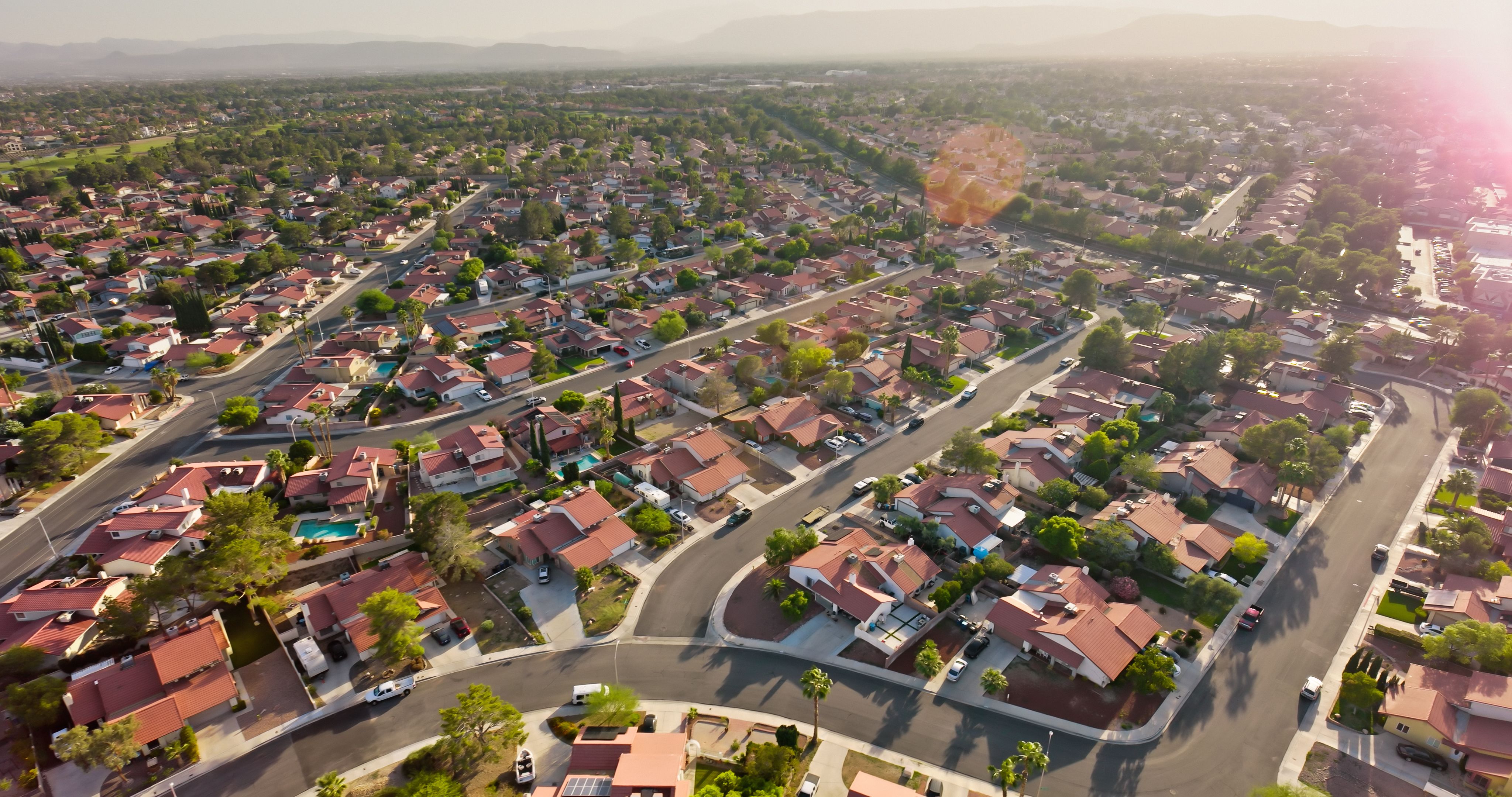 Picturesque wooden pier with huts extending over clear blue ocean waters on a sunny beach with white sand and bright sky