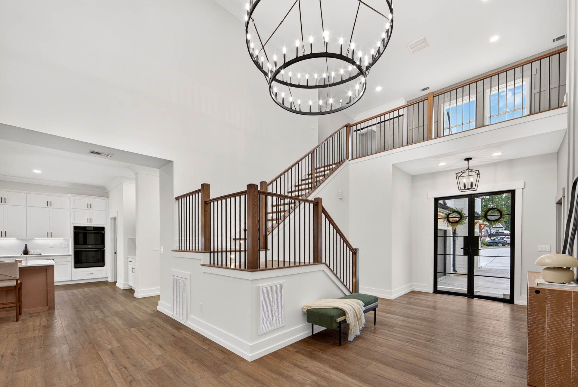 Two-story foyer with wrought-iron staircase and tall ceilings