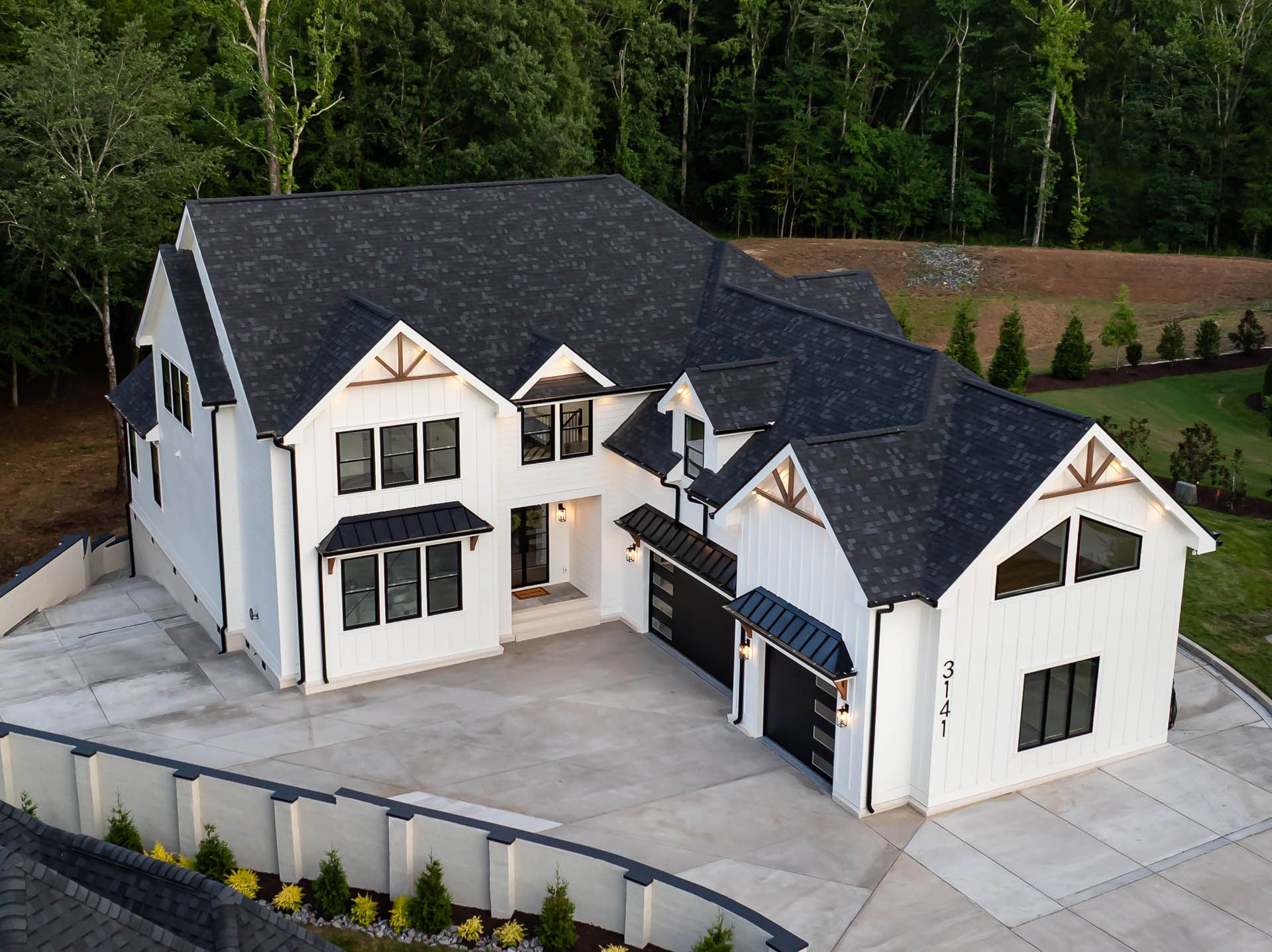 Twilight aerial view of 3141 Brayland Avenue surrounded by wooded property