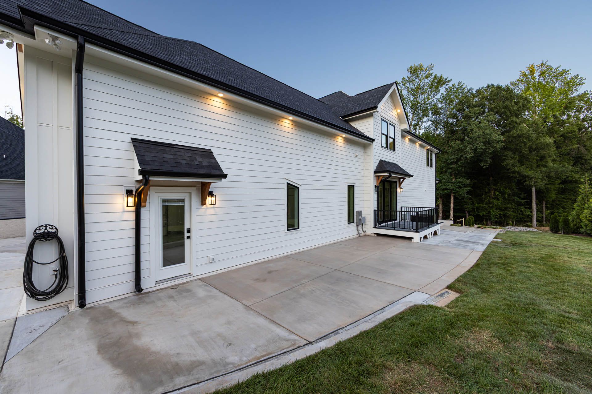 Daytime side exterior with lower deck and private backyard