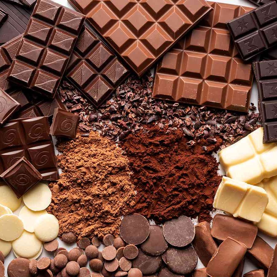 Freshly prepared crabs seasoned with seasoned bread crumbs, stacked on a dark plate on a wooden surface.