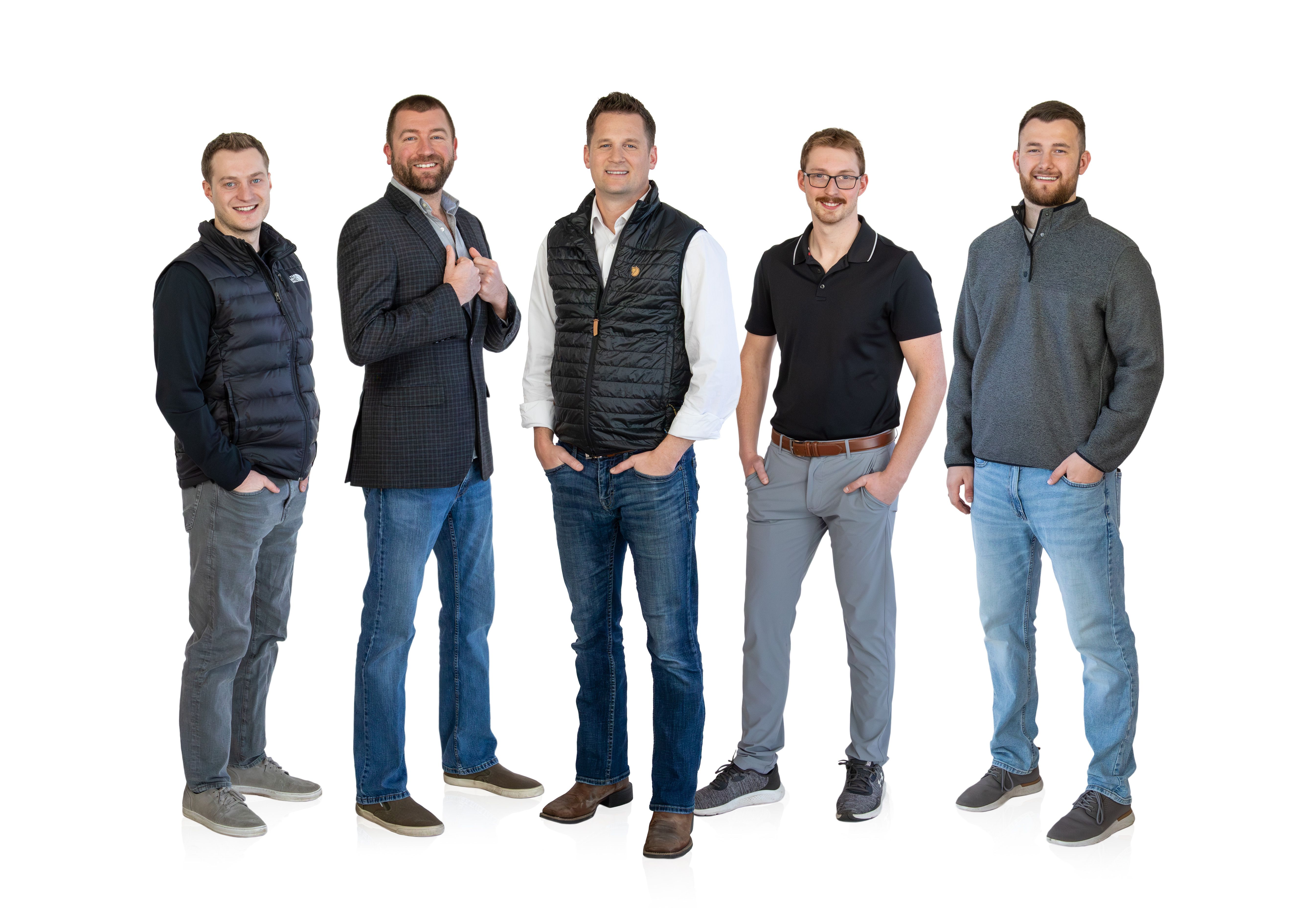 Smiling young man in a black blazer and white t-shirt, professional portrait with a plain white background.