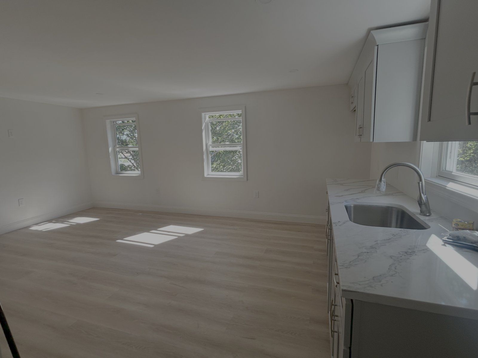 Renovated kitchen with quartz waterfall countertop and stainless sink — Park Street, Rockland, MA
