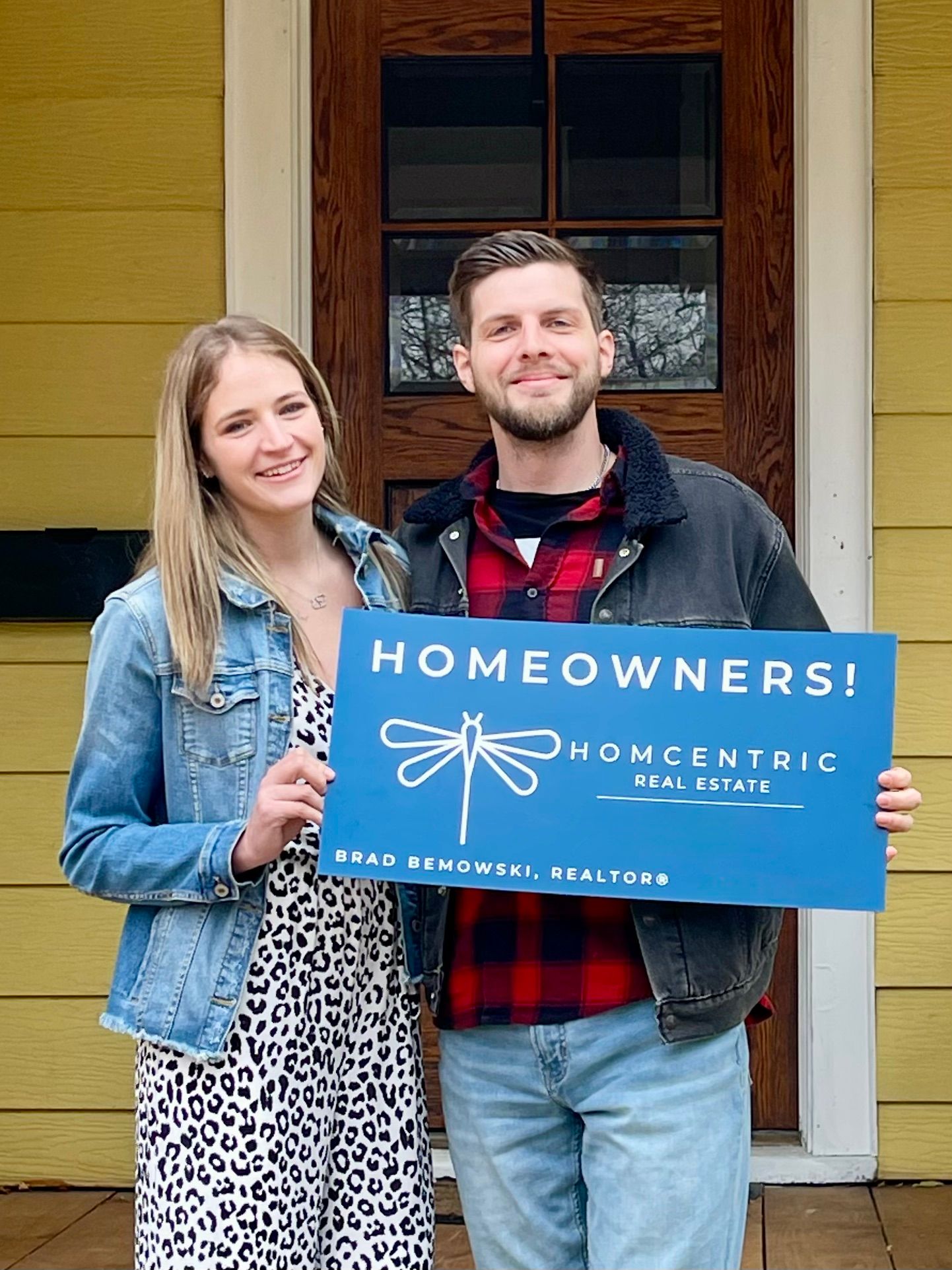 Happy home buyers with Homcentric Real Estate sign in Eau Claire WI
