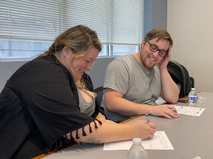 Home buyers signing paperwork at closing with Homcentric Real Estate in Eau Claire WI