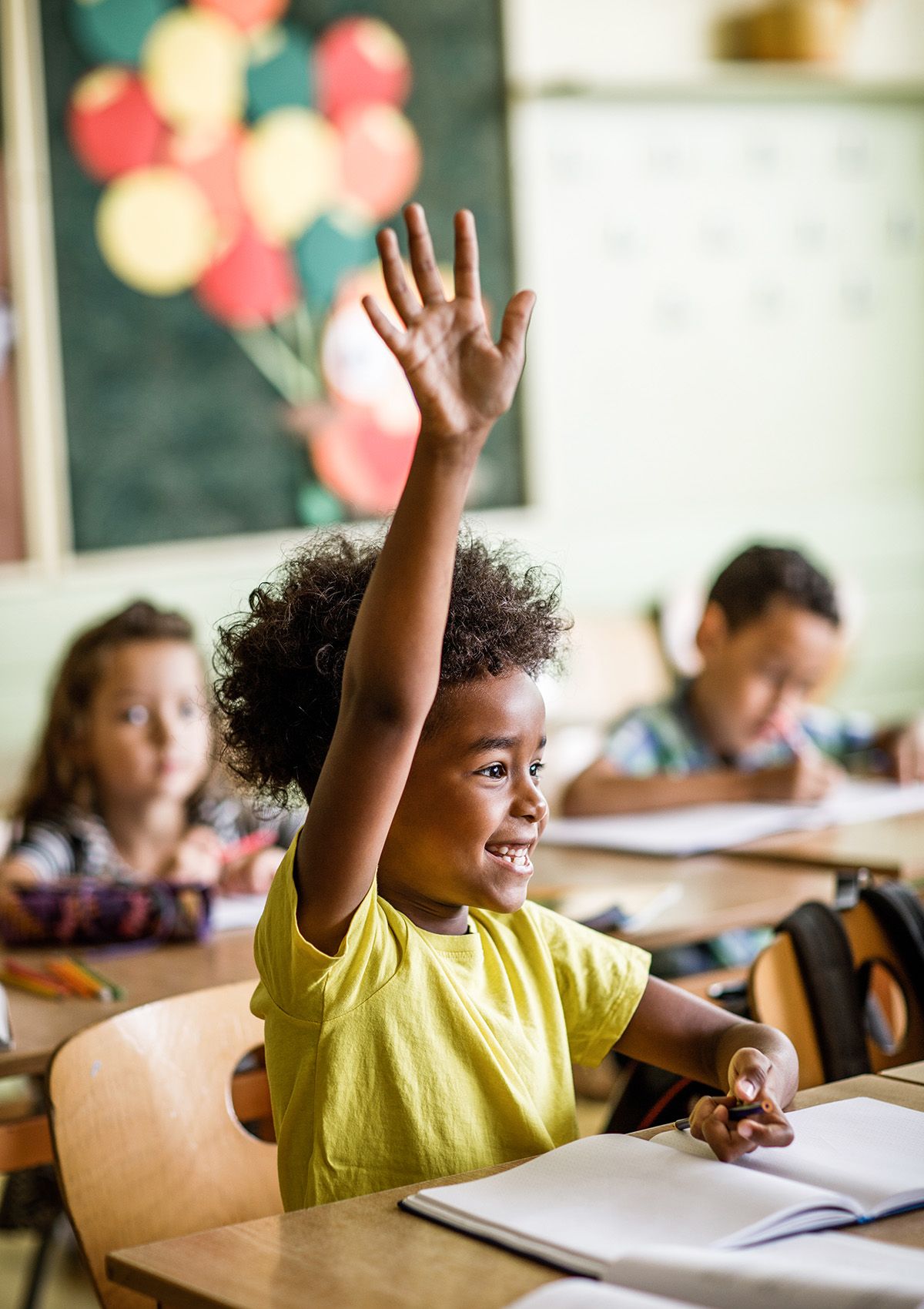 Child raising hand ins chool