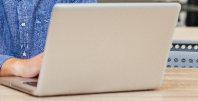 woman with glasses does paperwork by laptop