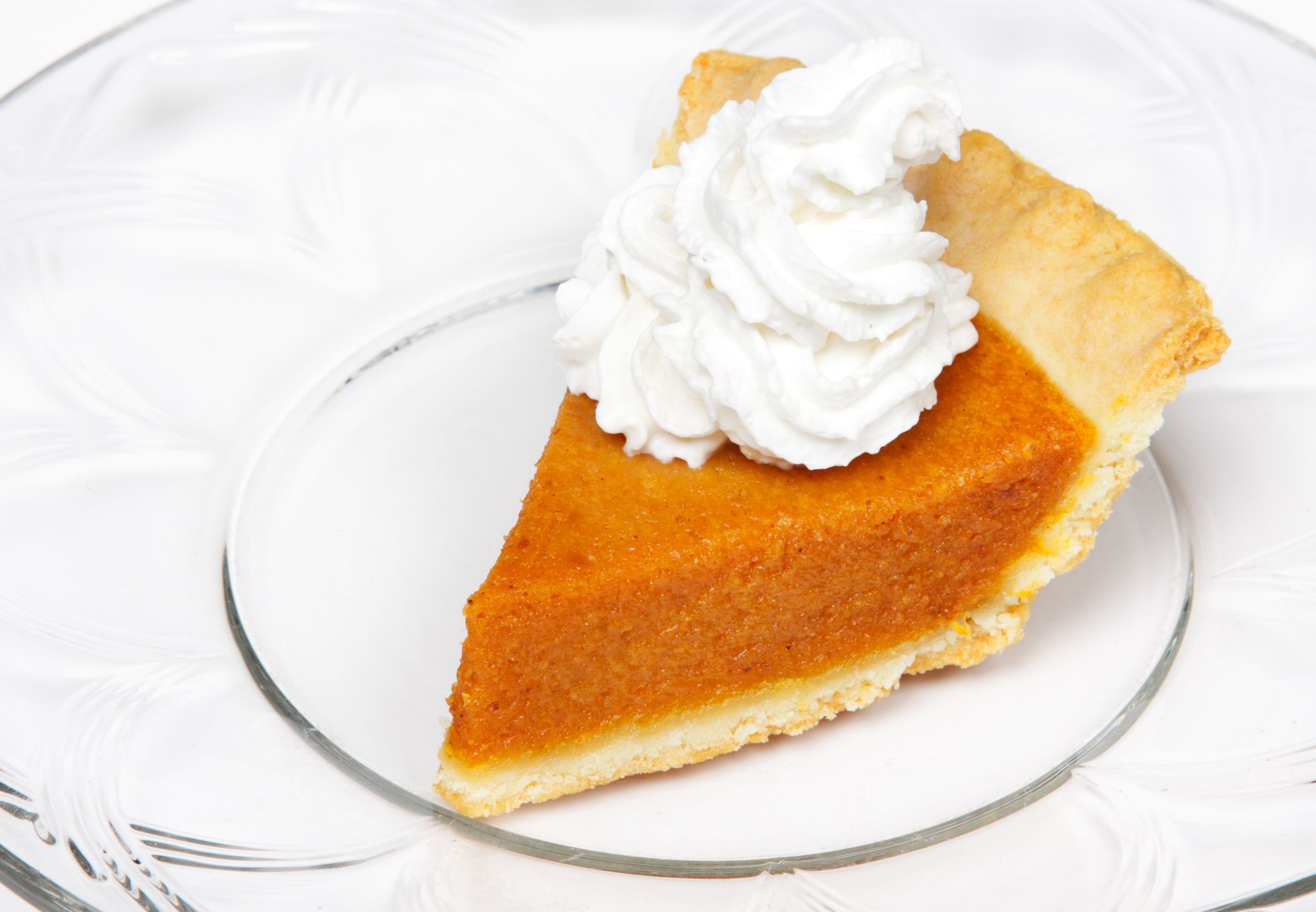 A slice of pumpkin pie with whipped cream