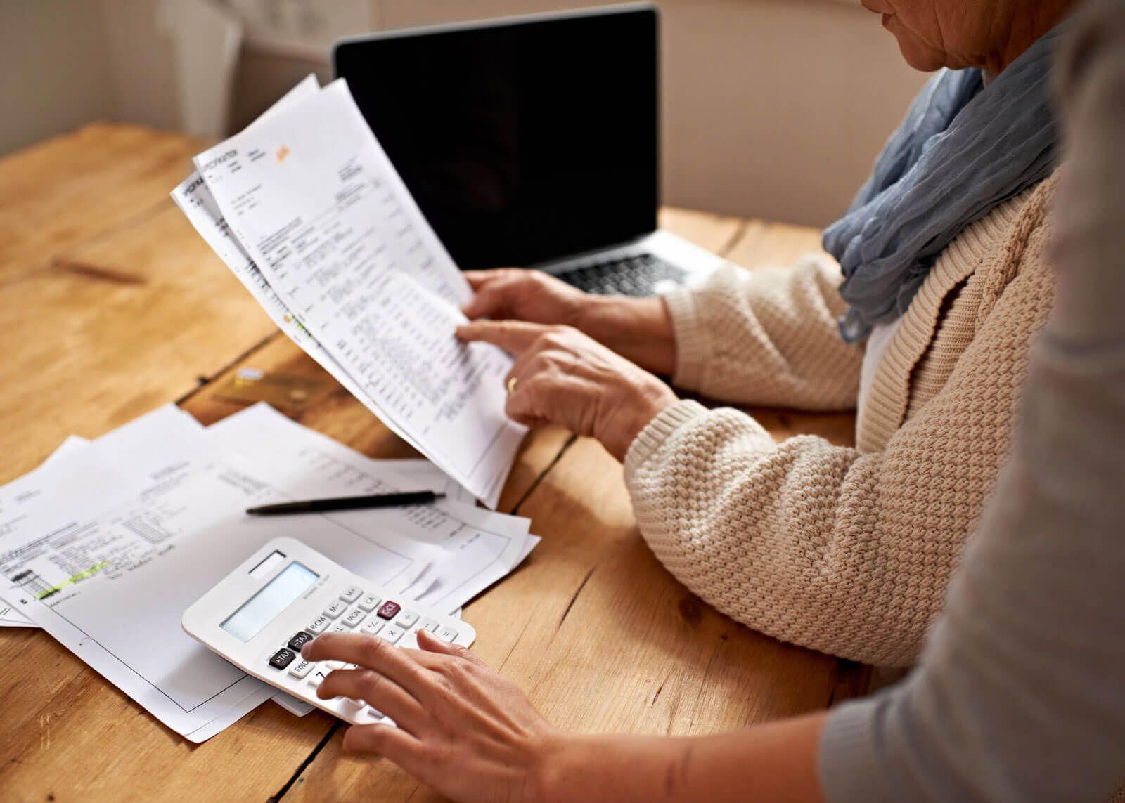 woman with glasses does paperwork by laptop