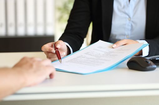 woman with glasses does paperwork by laptop