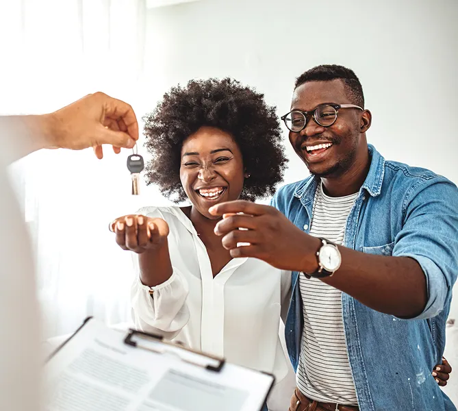 happy homeowners receiving their new house keys