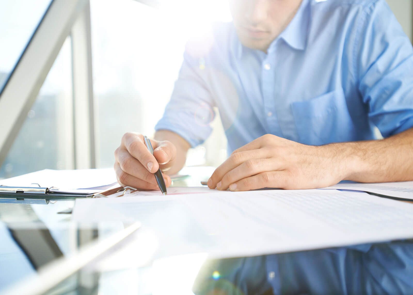 woman with glasses does paperwork by laptop