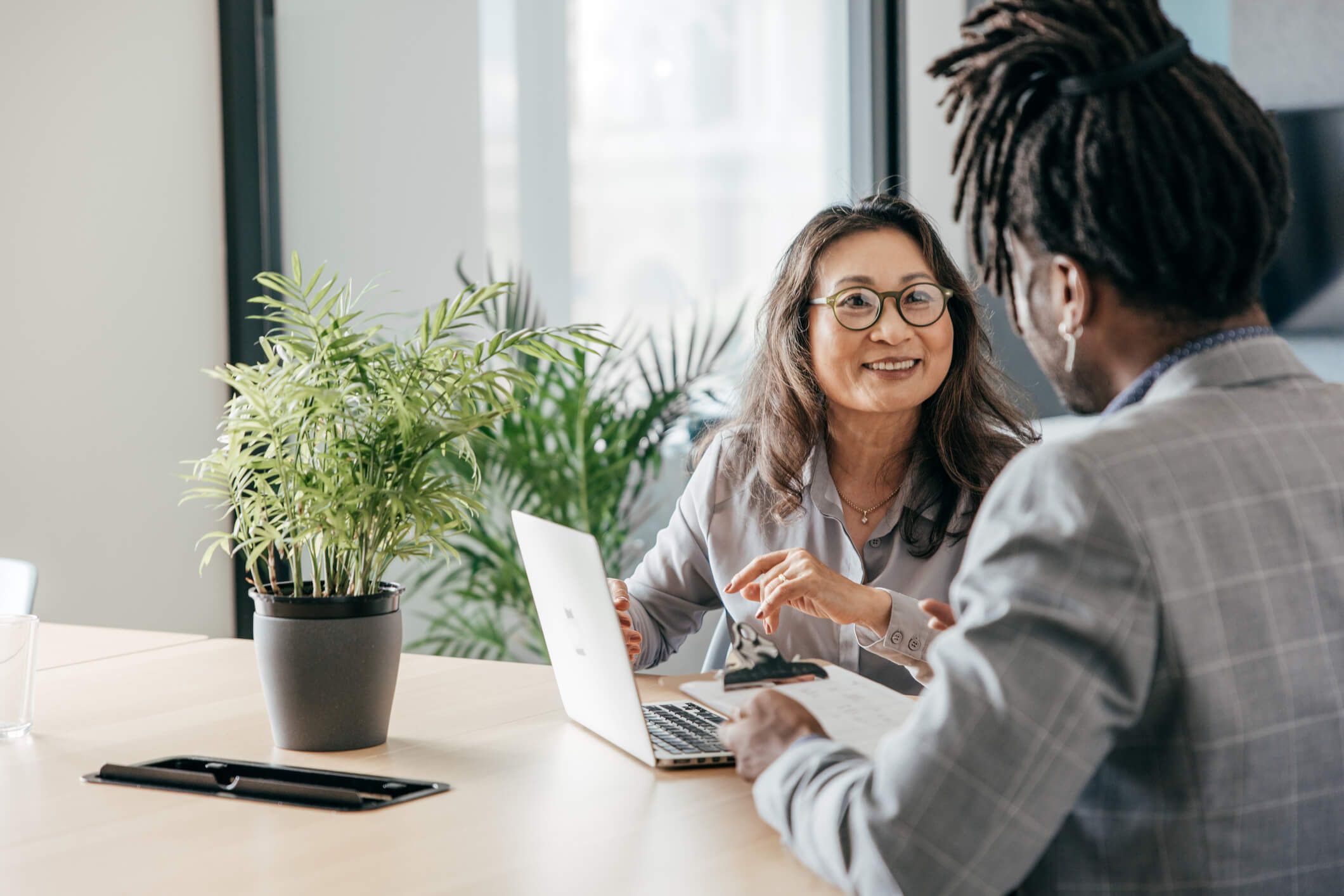 woman with glasses does paperwork by laptop
