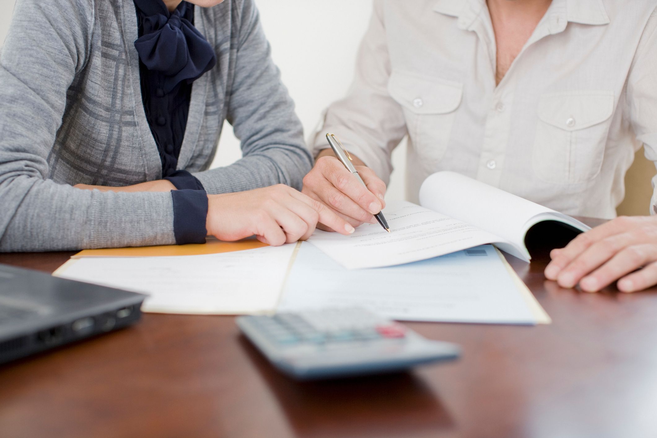 woman with glasses does paperwork by laptop