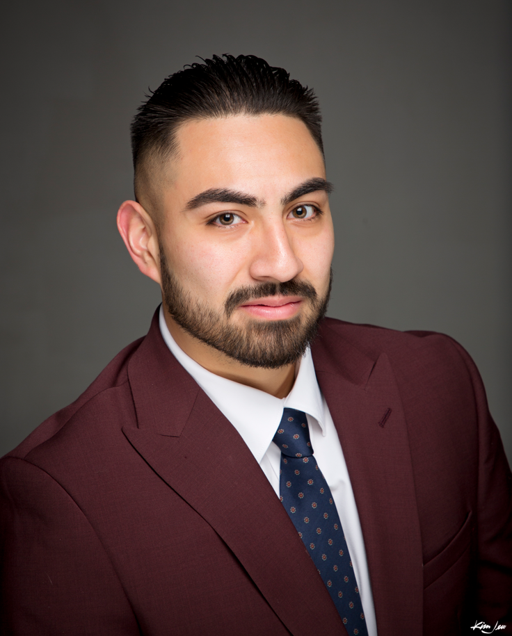 Portrait of a man in a plaid suit with glasses and a purple background