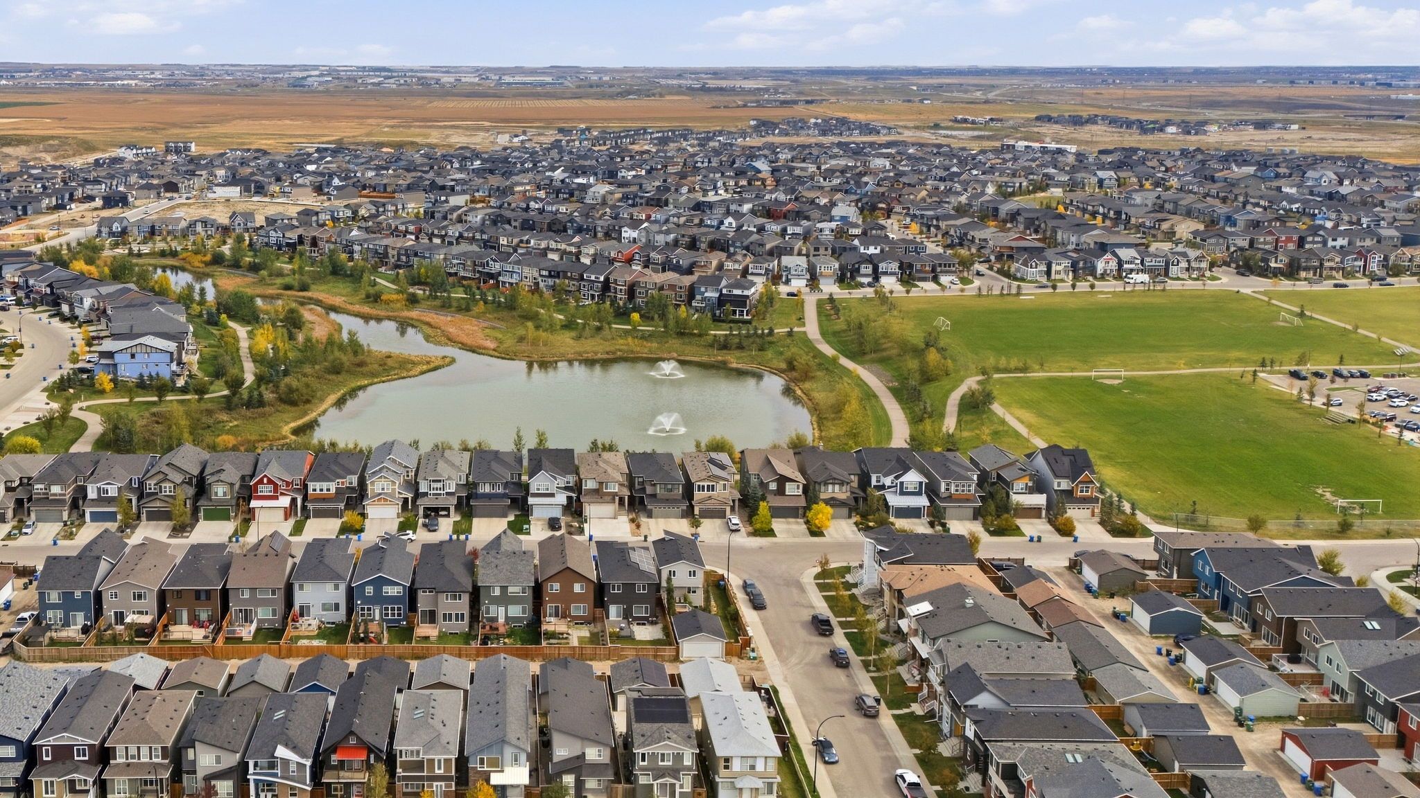 Aerial view of the community pond, pathways and green space in Livingston, north Calgary