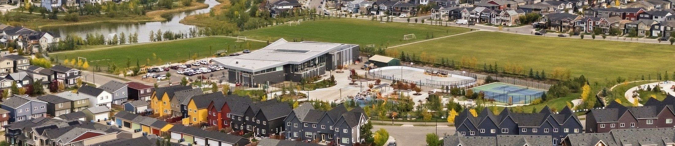 Aerial view of the Livingston Hub community centre in north Calgary with its skating rink, tennis courts, splash park and sports fields