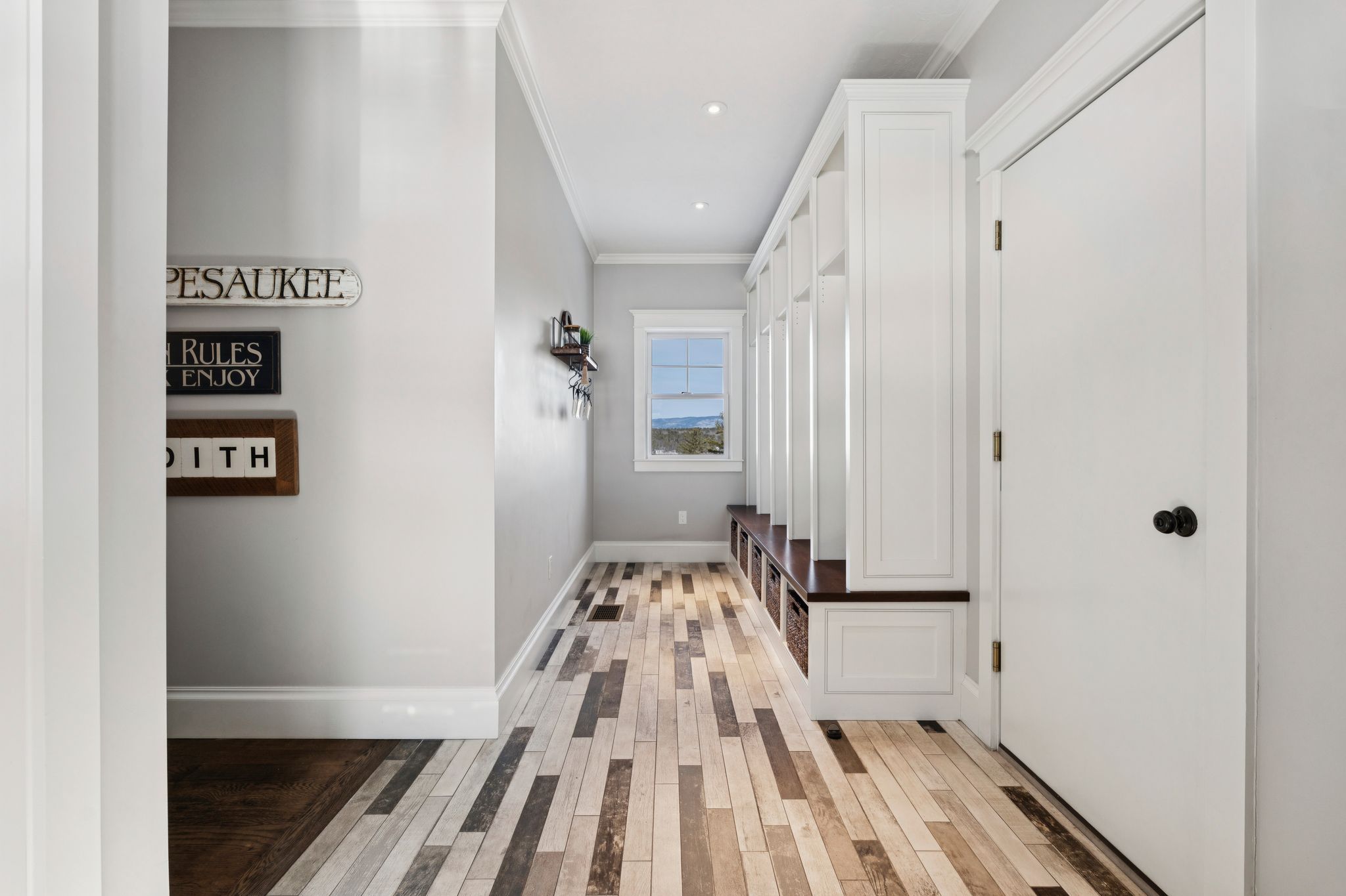 Spacious living room with large windows, high vaulted ceiling, cozy seating area, and modern decor in a bright, open-concept home.