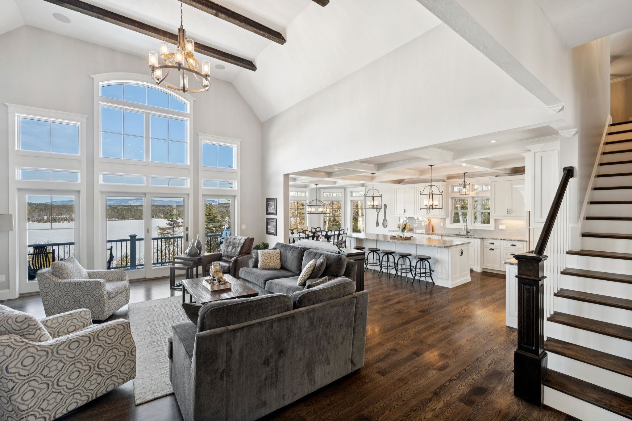 Interior view of a white front entryway with a decorative door featuring a stained glass wreath design, and a white built-in coat rack with hooks and storage space for shoes and accessories.