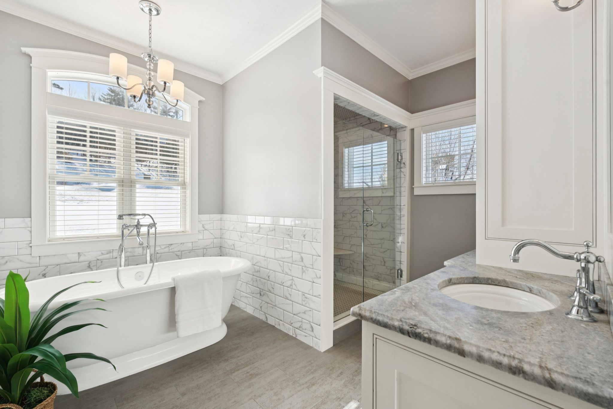 Modern small bathroom with vessel sink, white vanity, framed mirror, wooden paddle art, and toilet with toilet paper holder