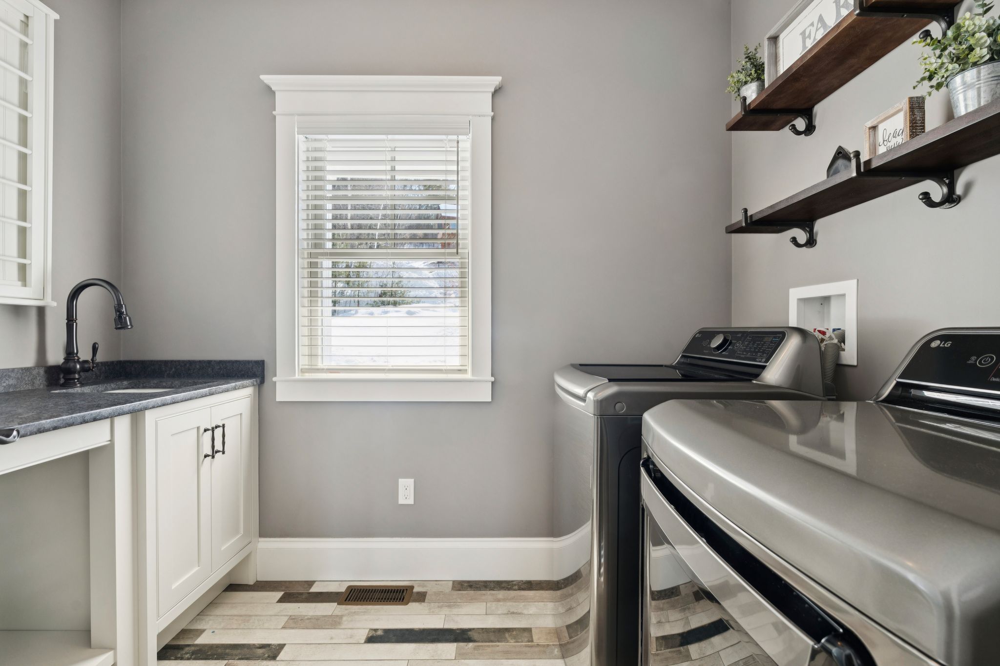 Modern small bathroom with white fixtures, wooden flooring, towel rack, framed art, and white shower curtain