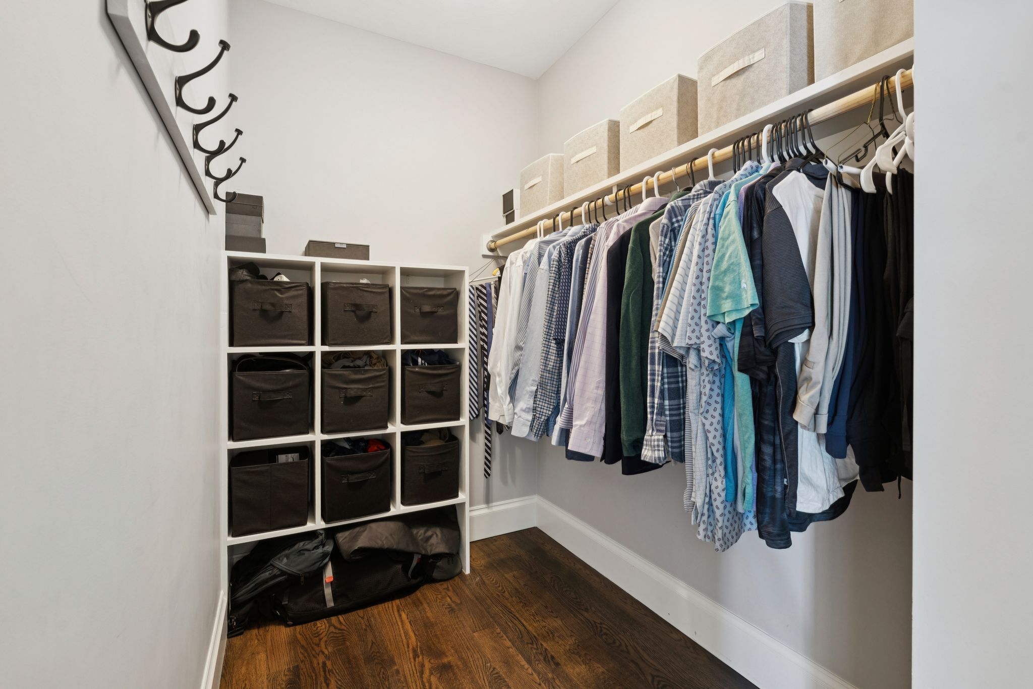 Modern laundry room with white washer and dryer, gray tiled floor, beige wall, colorful dog artwork, and wall sign reading The Laundry Co Self Serve So Clean.