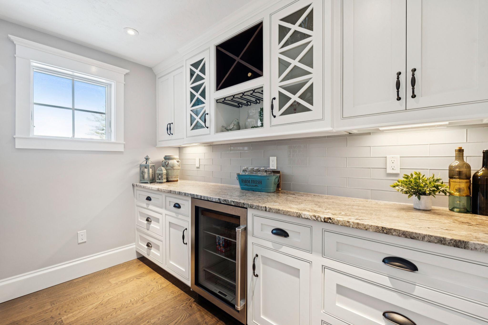 Spacious basement game room with shuffleboard, pool table, and seating area, featuring large windows and hardwood floors.