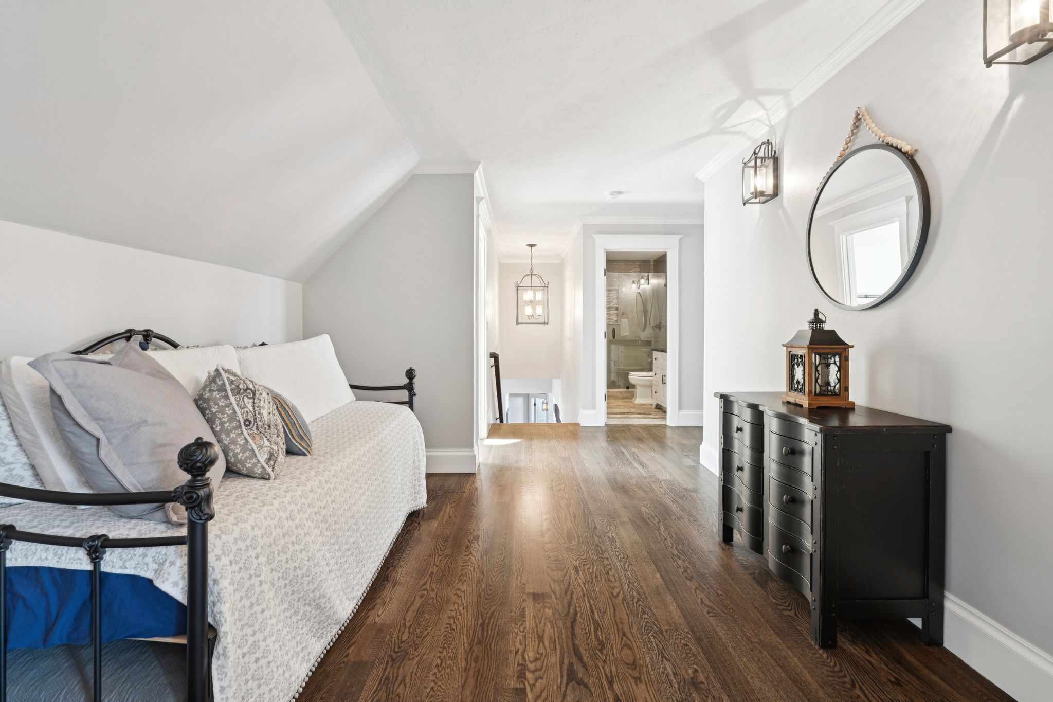 Spacious basement game room with shuffleboard, pool table, and seating area, featuring large windows and hardwood floors.