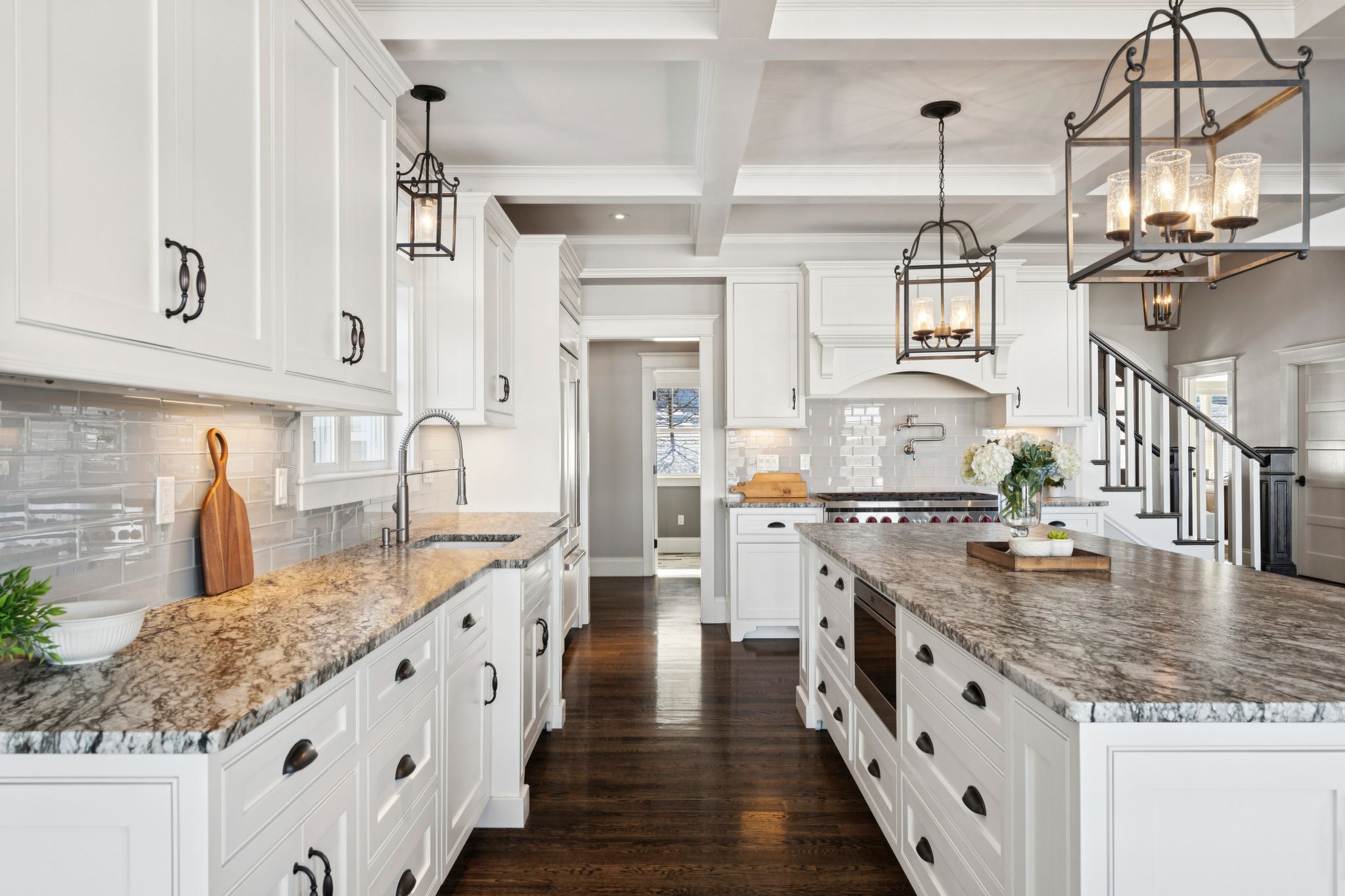 Spacious open-concept living room with high vaulted ceilings, large windows, contemporary furniture, area rugs, and modern décor.