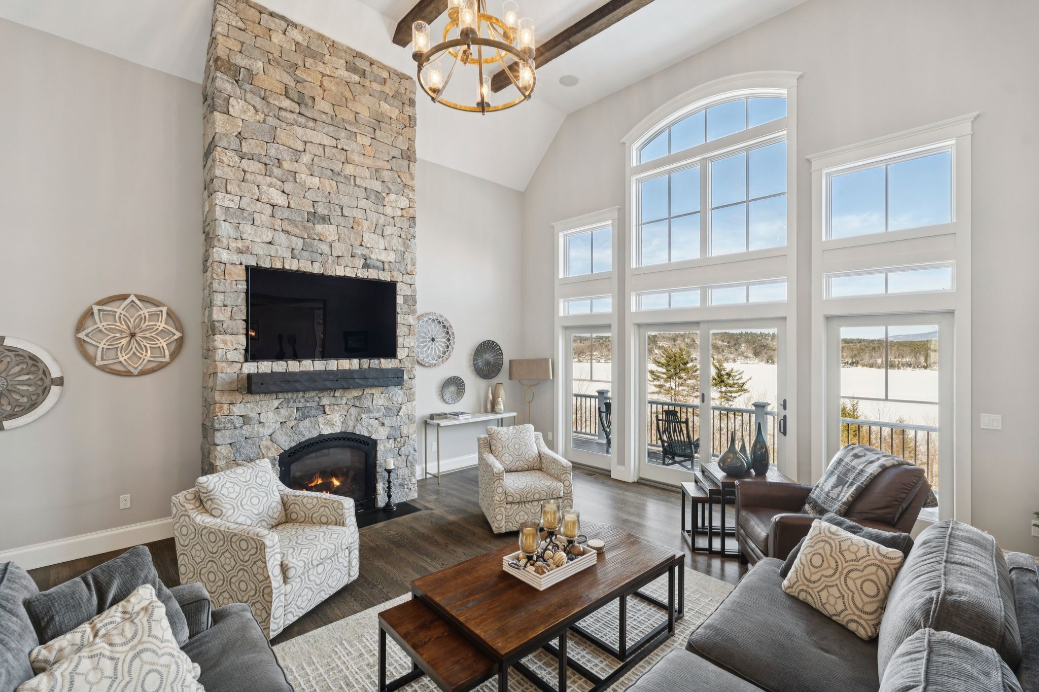 Modern kitchen with stainless steel appliances, wooden cabinetry, granite countertops, mosaic tile backsplash, and hardwood flooring in an open-concept living space
