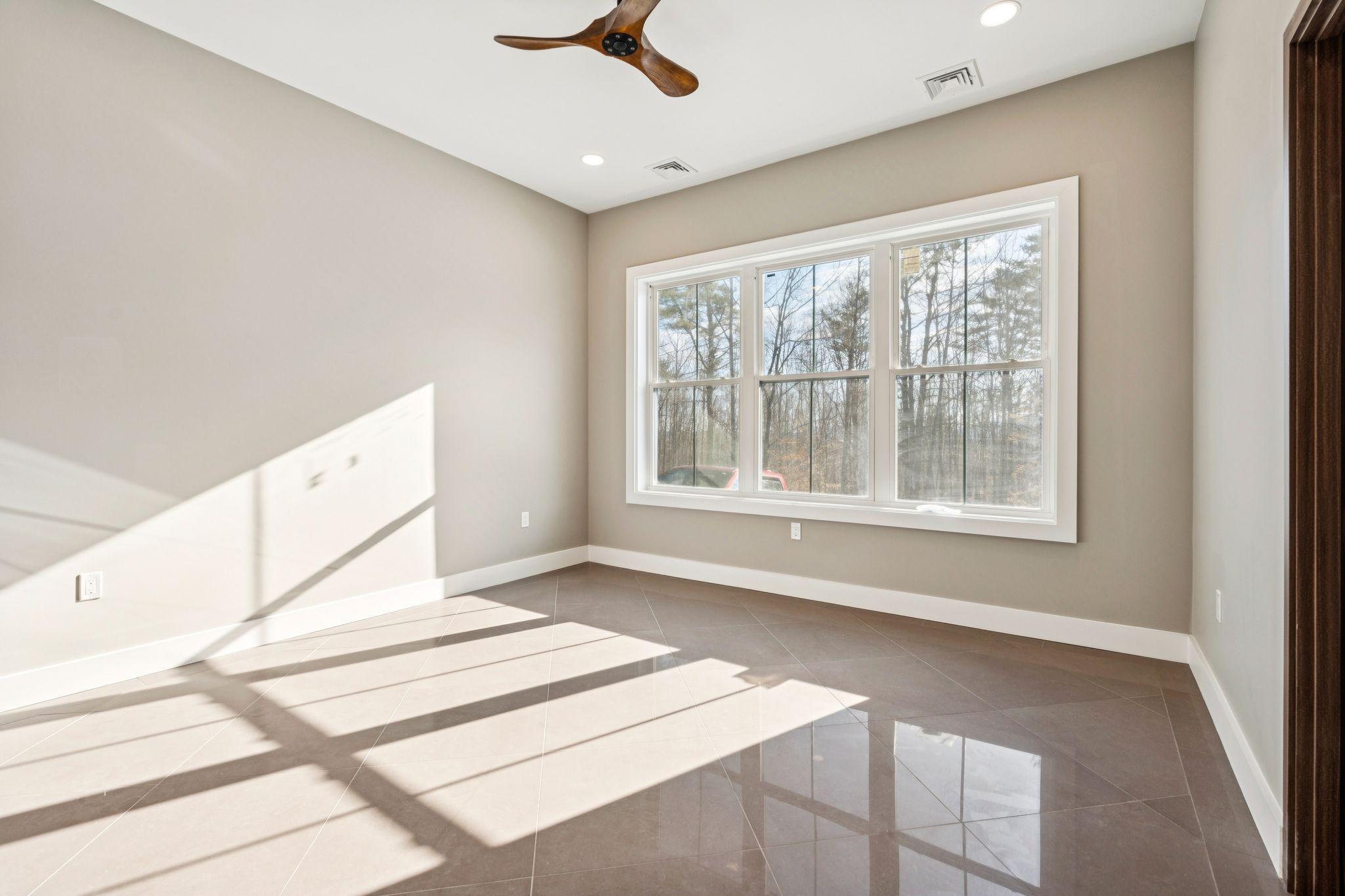 Modern white kitchen with granite countertops, stainless steel appliances, and hardwood flooring.