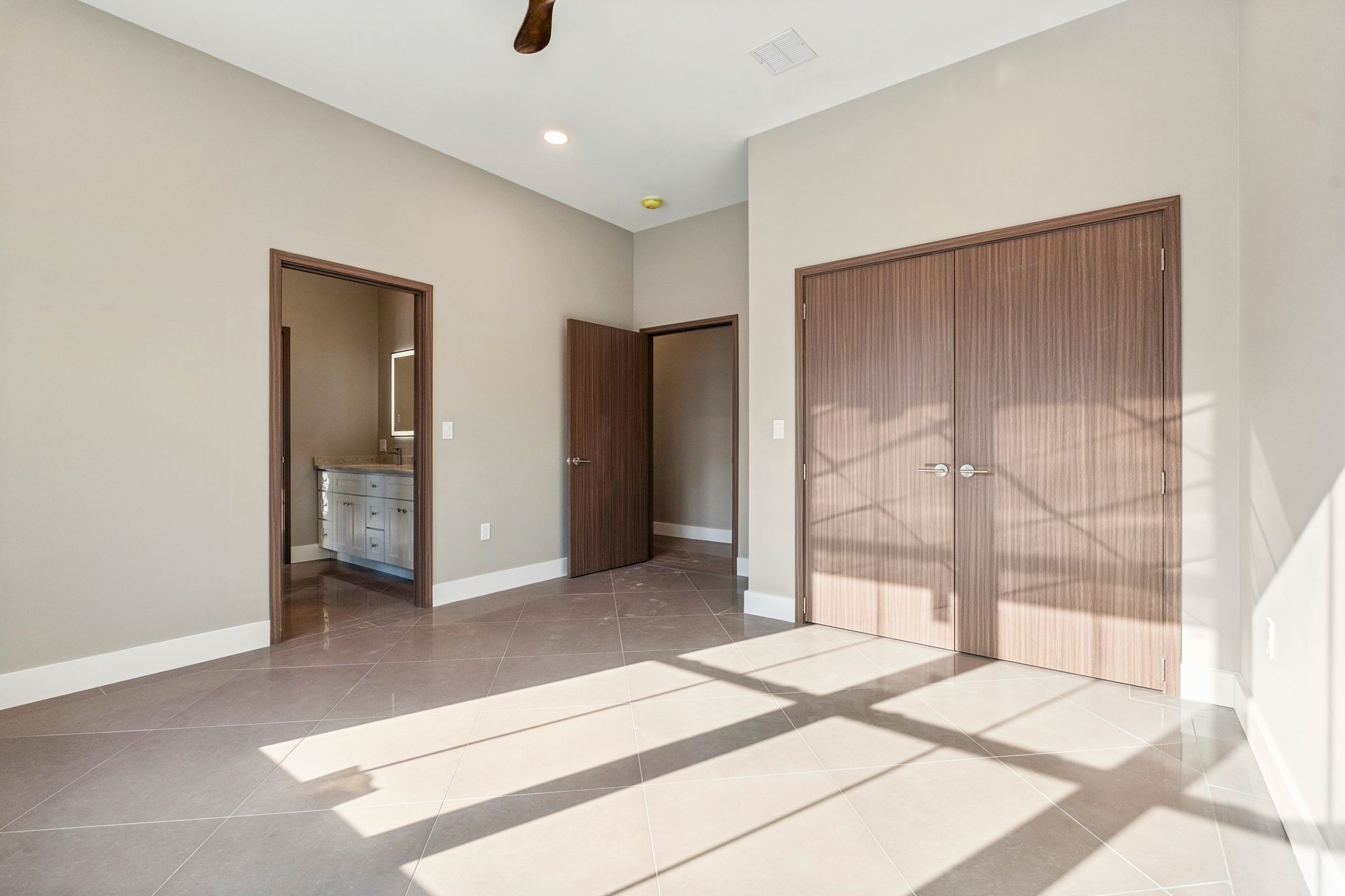 Modern farmhouse kitchen with white cabinetry, granite countertops, farmhouse sink, large windows with scenic lake and wooded views, and black pendant lighting.