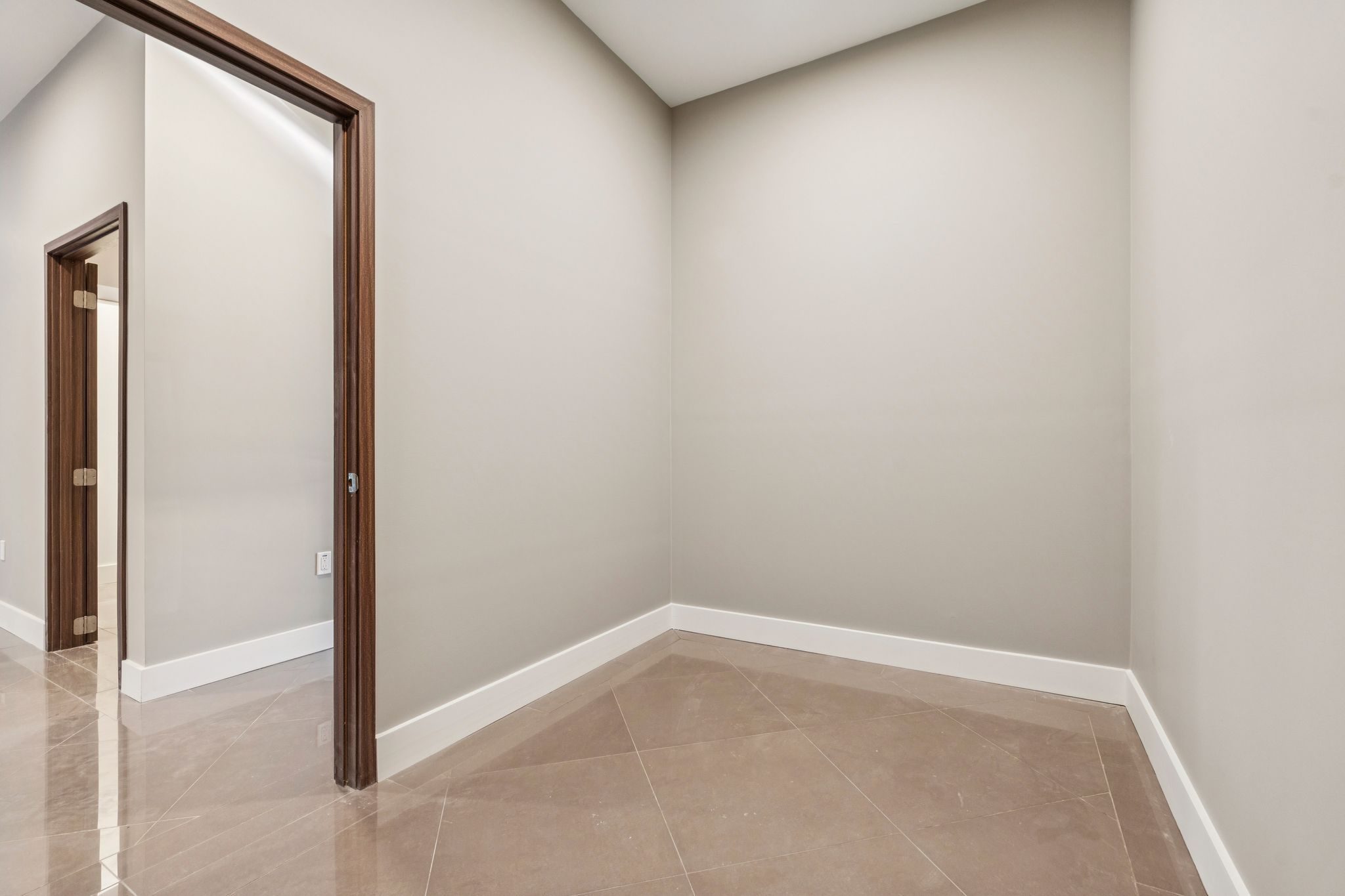 Bright modern kitchen with white cabinetry, granite countertops, stainless steel appliances, hardwood flooring, and large windows overlooking a snowy landscape.