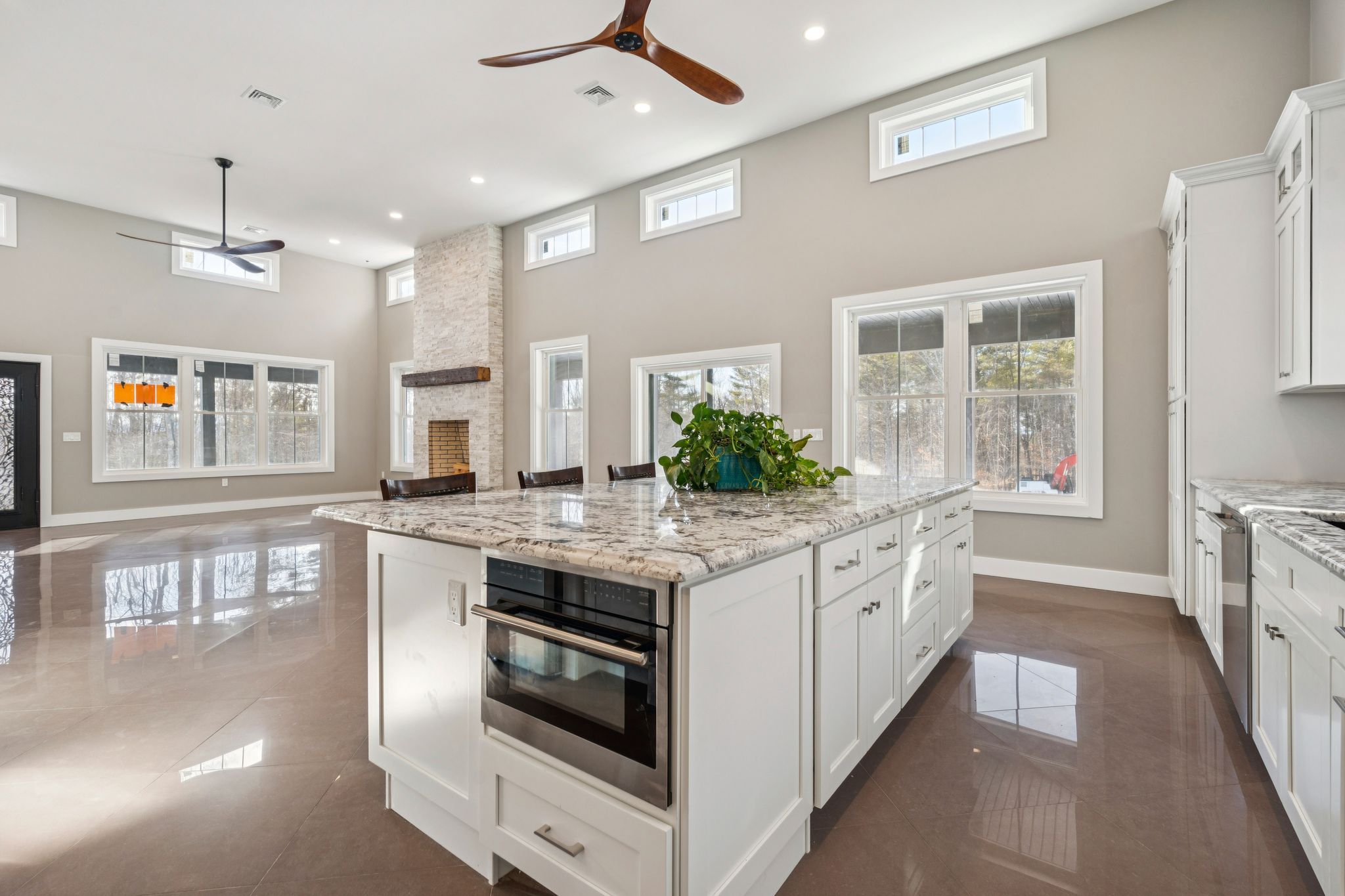 Inviting entryway with a decorative rug, wooden console table, mirror, and staircase with wrought iron railing in a modern home interior.