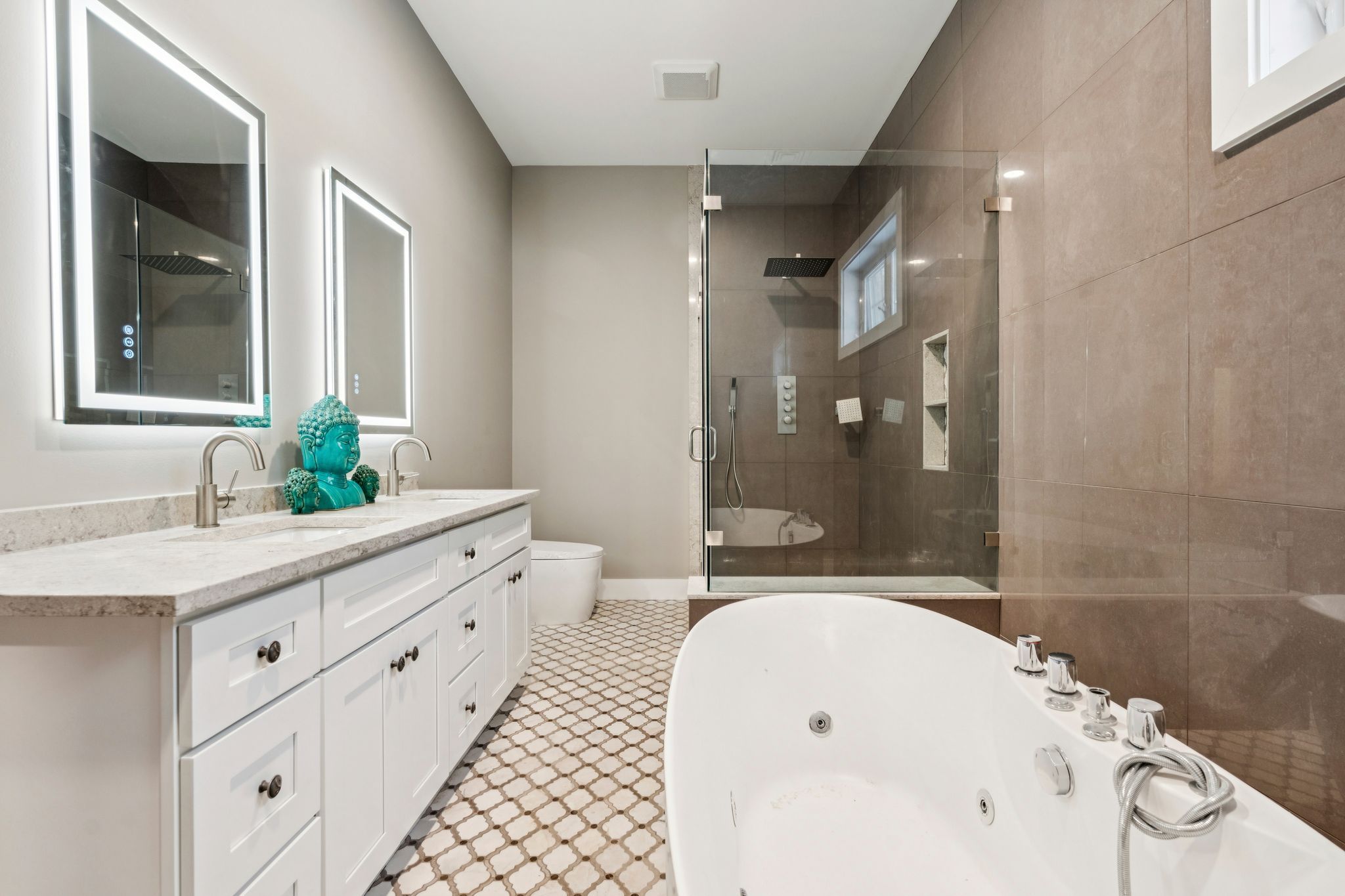 Interior view of a room with large sliding glass doors leading to a snow-covered deck overlooking a frozen lake with trees in the background.